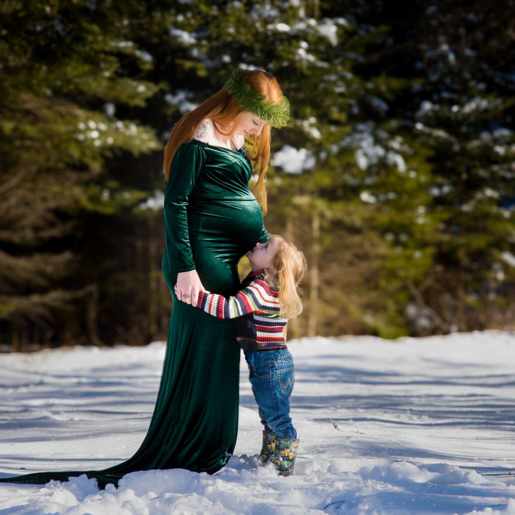 Maternity portrait by Northern Exposure featuring a horse standing in front of a sign with the announcement on the board
