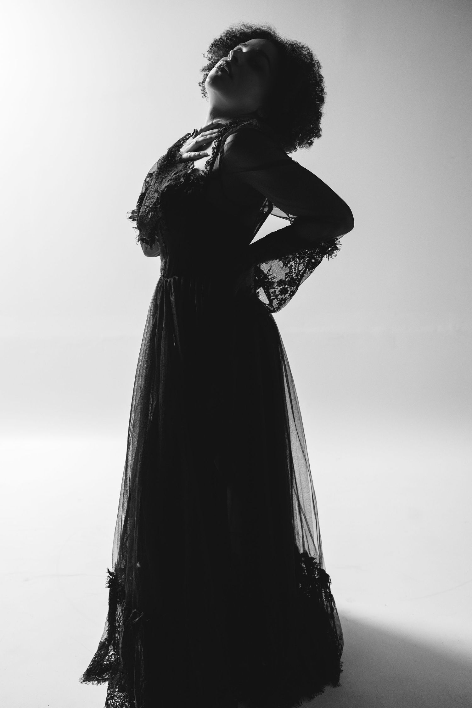 Dramatic black and white silhouette portraits showing figure in flowing dark clothing against light background.