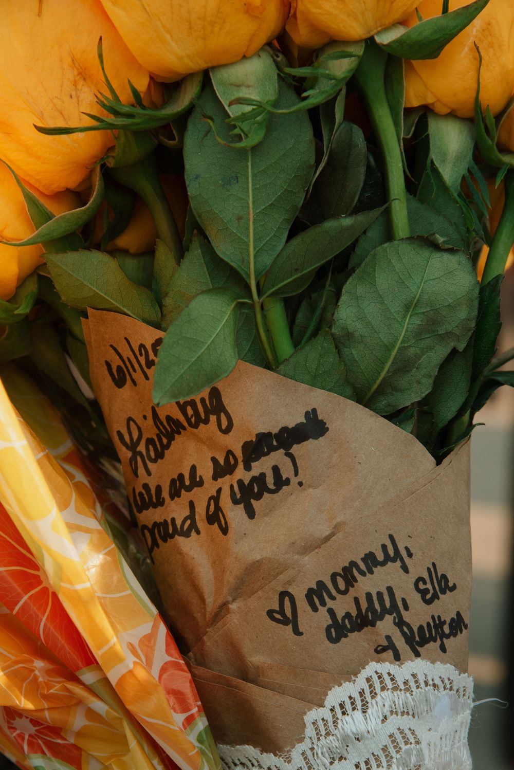 Close-up of yellow roses with handwritten notes on brown paper wrapping.