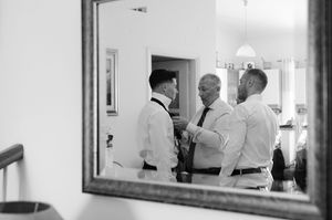Black and white getting ready photos showing wedding day preparations through mirror reflections.