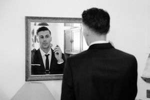 A sequence of getting ready shots showing formal wear adjustments in a mirror.