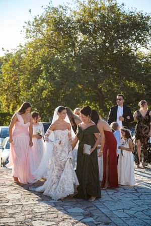 Wedding guests gather on stone patio during outdoor celebration at sunset.