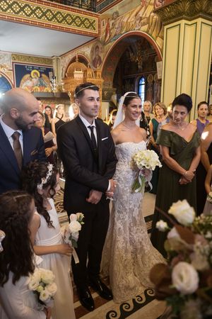 Orthodox church wedding ceremony with ornate painted walls and decorative details.