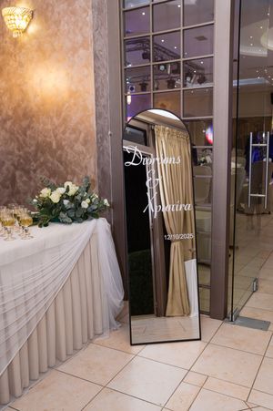 Elegant wedding reception setup with white draped tables and floral arrangements in a modern venue.