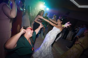 People dancing and having fun at a nightclub with colorful lights and a lively atmosphere.