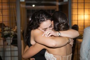 Couples dancing together at an indoor wedding reception with warm lighting.