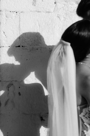 Black and white abstract image showing shadows and fabric draping against a white wall.