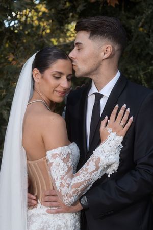 A romantic wedding photoshoot capturing intimate moments between newlyweds in formal attire.