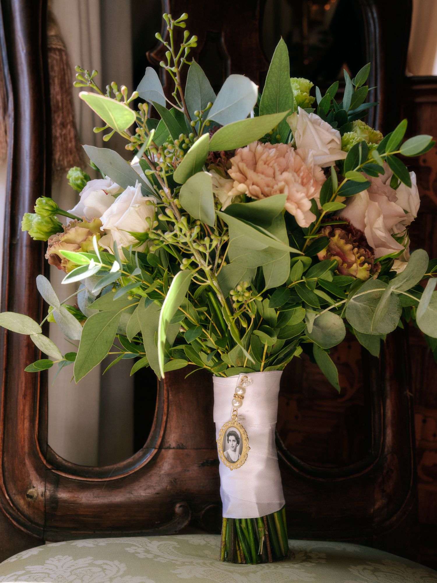 Elegant wedding bouquet arrangements with white and blush flowers and eucalyptus greenery displayed in white vases.