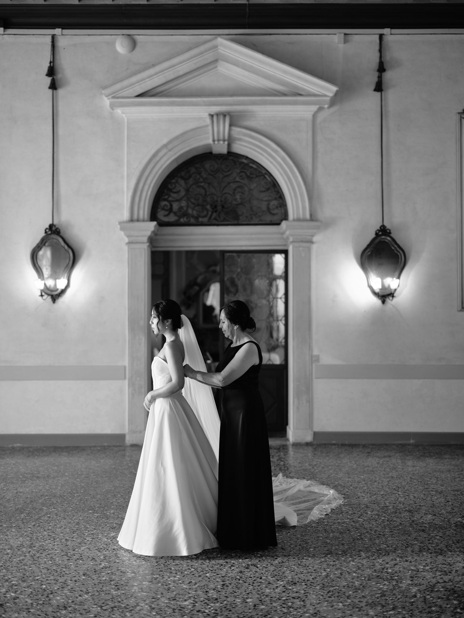 A black and white photo series shows a couple in formal attire dancing in an elegant hallway with arched doorways.
