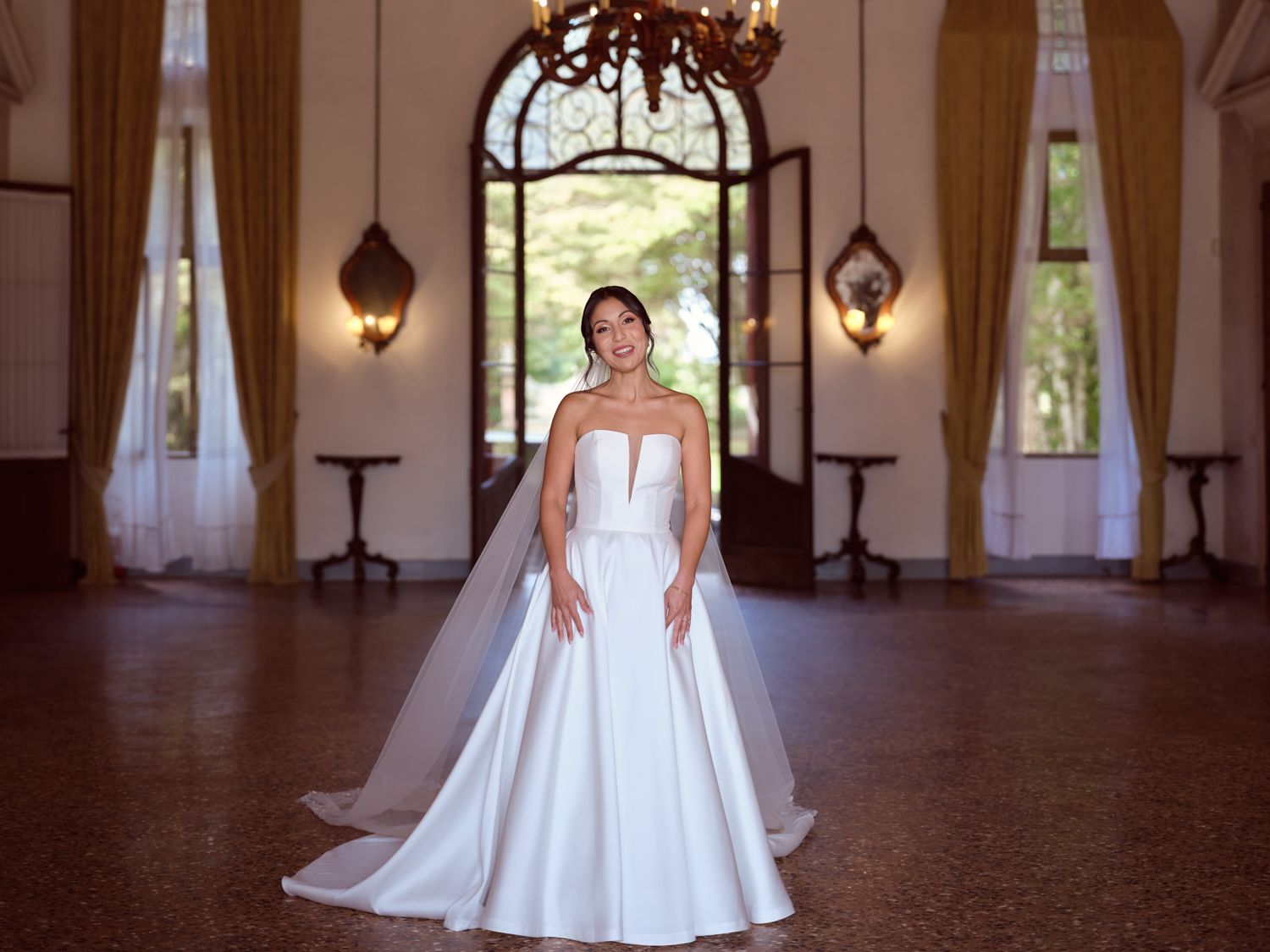 A sequence of photos showing a wedding dress in a grand ballroom with elegant windows and chandeliers.