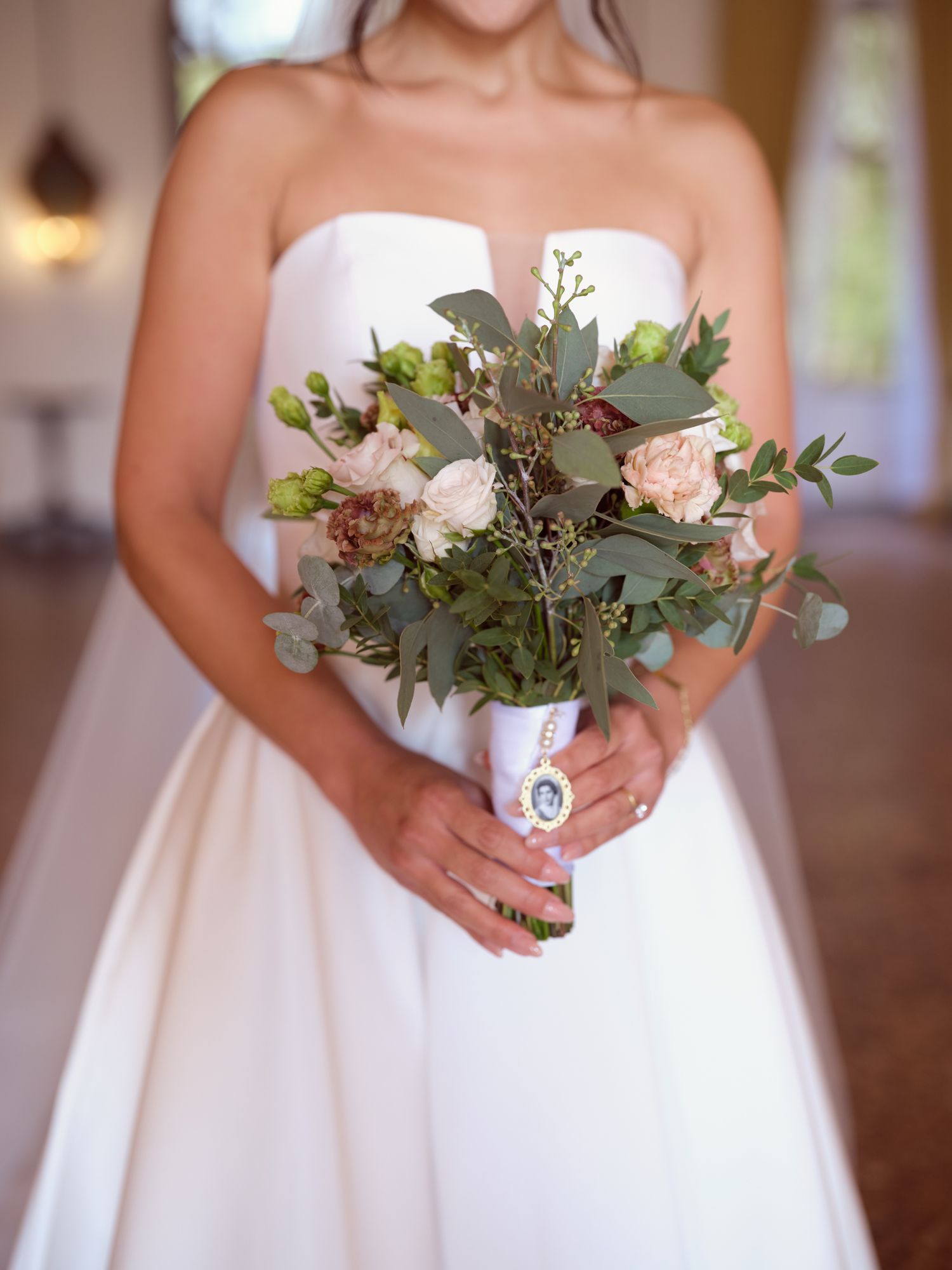 A series of elegant wedding bouquets featuring pink and white roses with eucalyptus leaves against white bridal gowns.