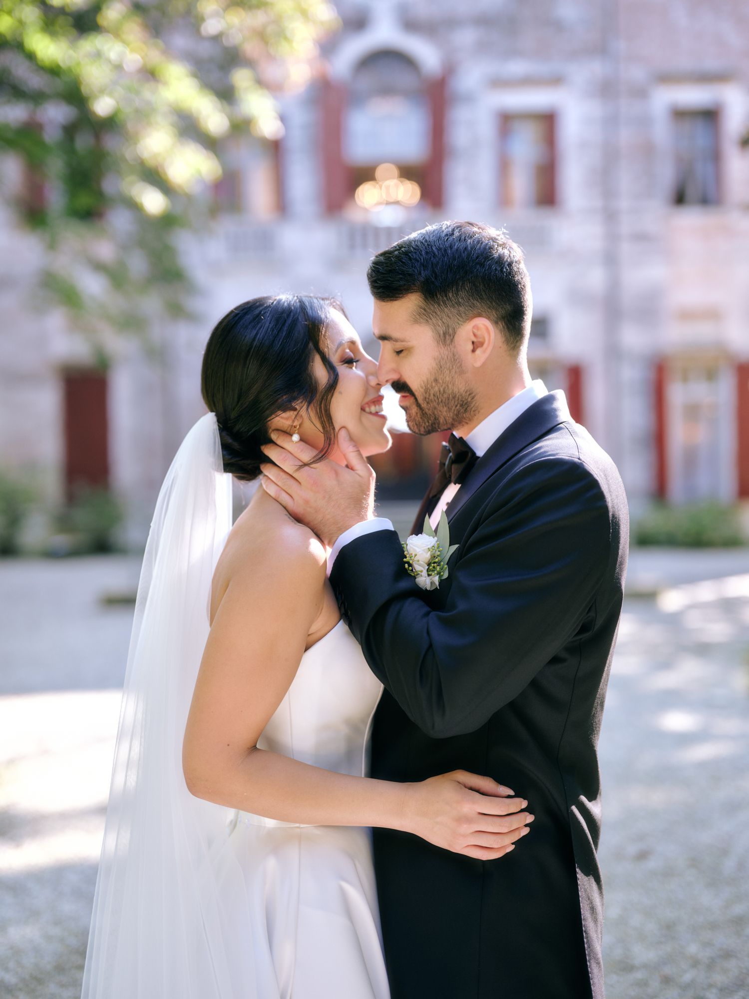 A romantic sequence of wedding photos shows a couple sharing their first kiss as newlyweds outside a historic building.
