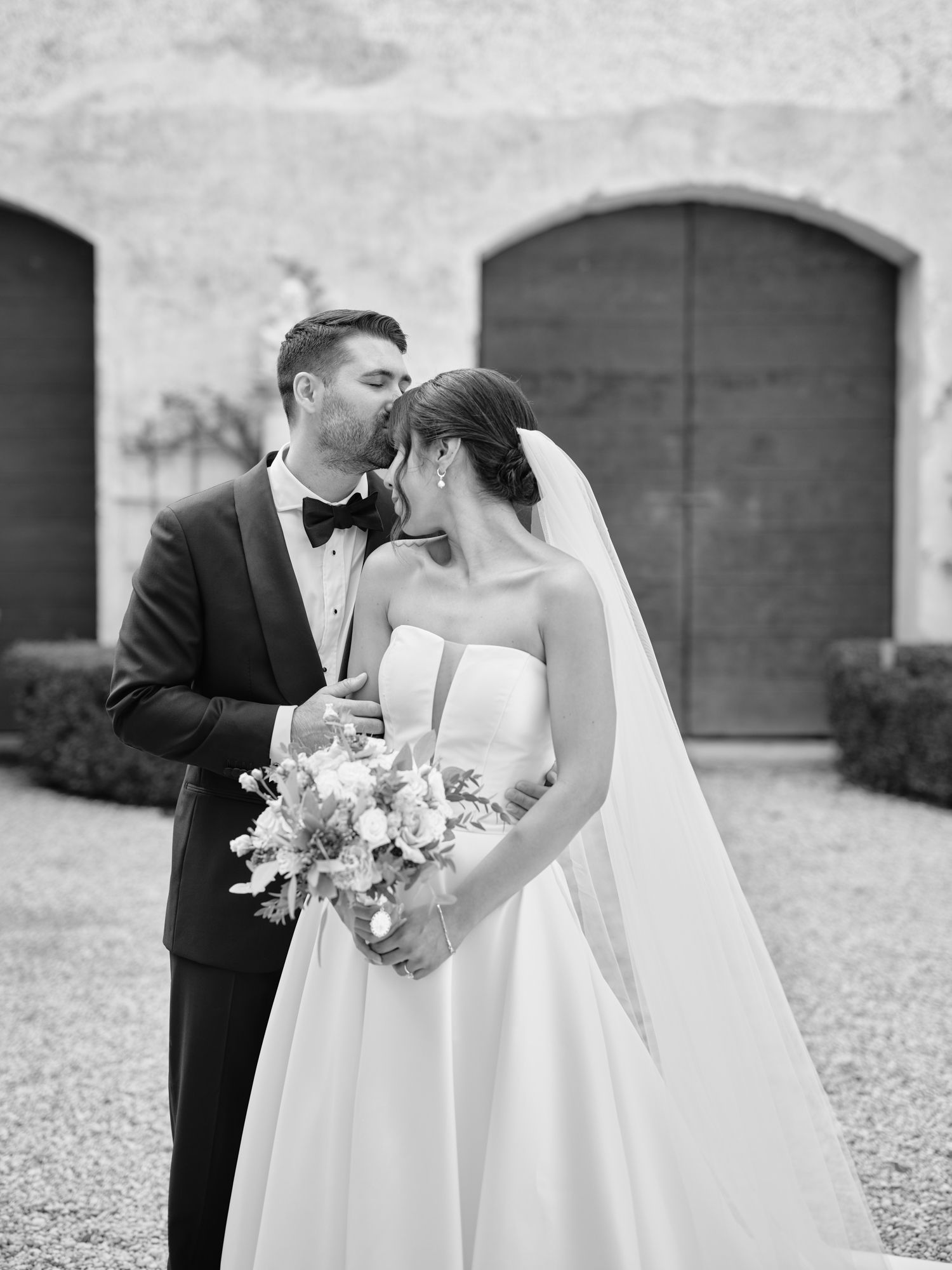 Black and white wedding photos show romantic moments between newlyweds in an outdoor garden setting.