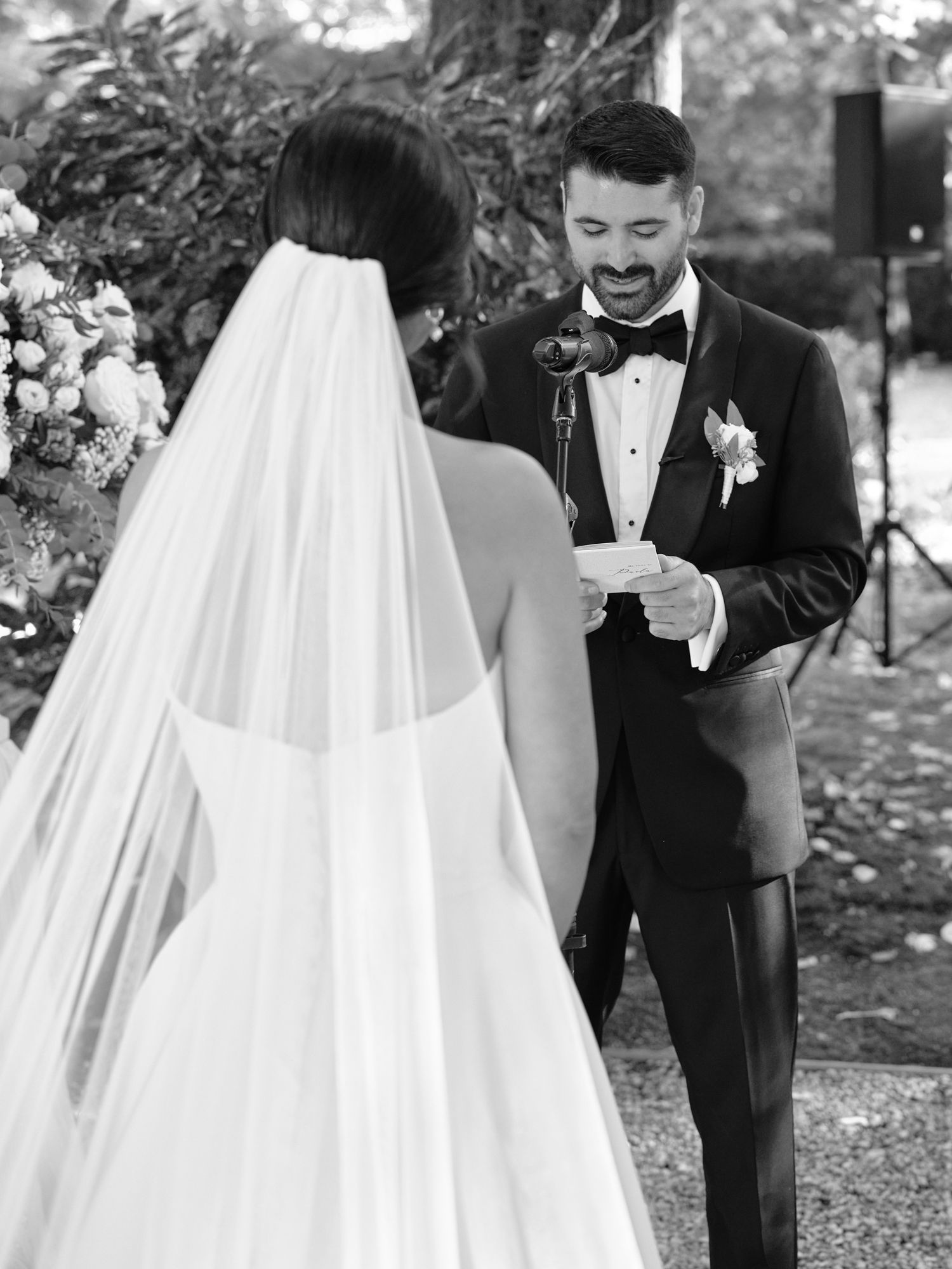 A romantic wedding moment captured in a sequence of five black and white photos showing a couple exchanging rings outdoors.