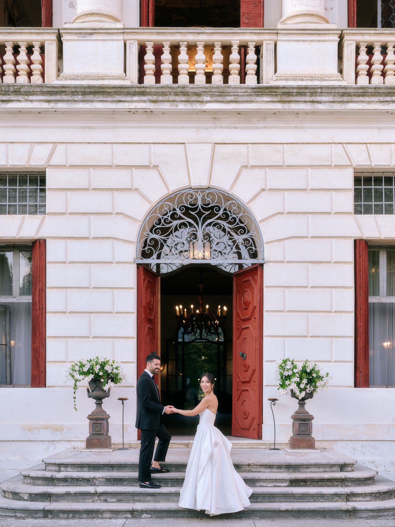 A series of elegant wedding photos showing a couple in formal attire against a classic white building facade with red shutters.