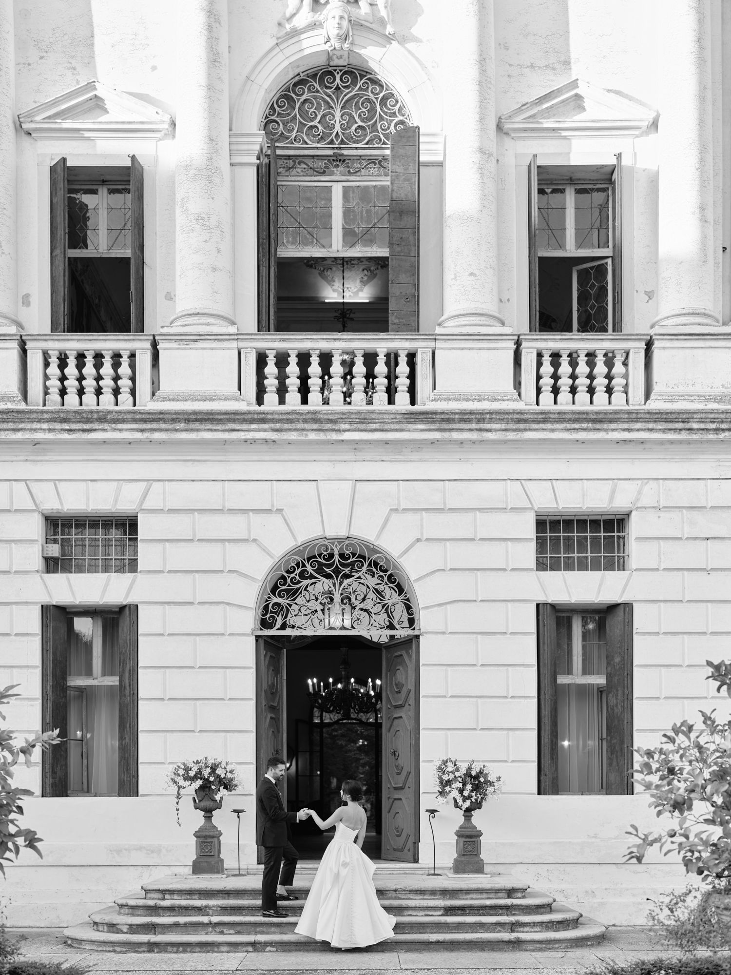 Classic black and white photograph of a grand building entrance with ornate architecture and stone balustrades.