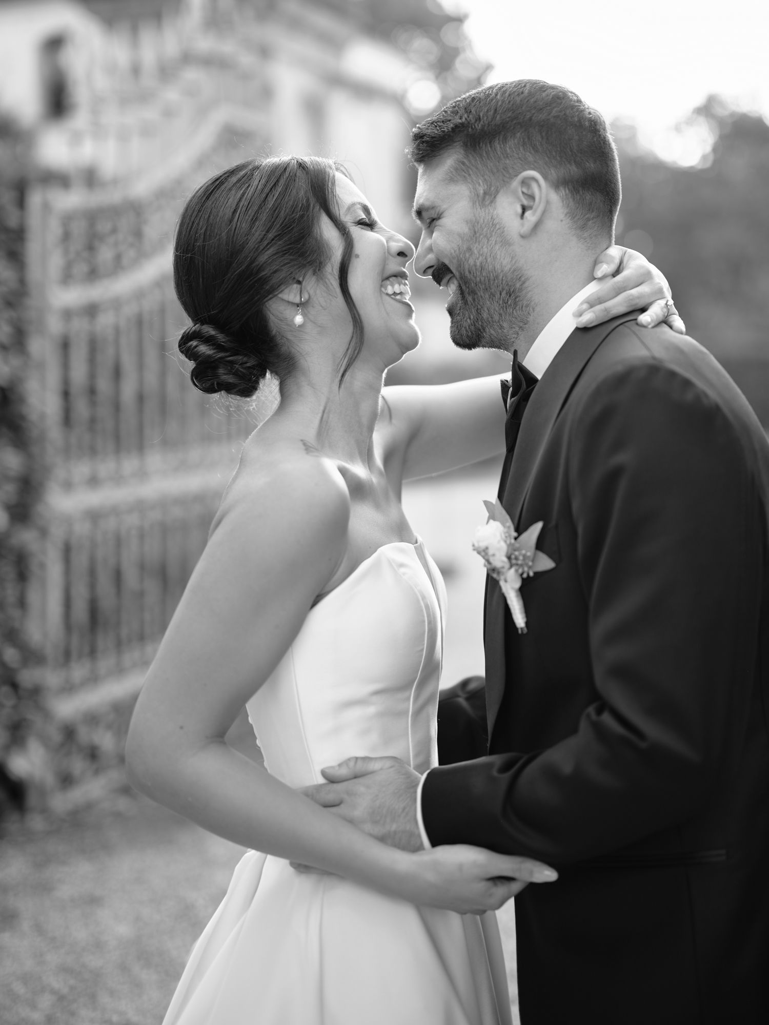 A romantic black and white wedding photo series showing a couple embracing and kissing in formal attire.