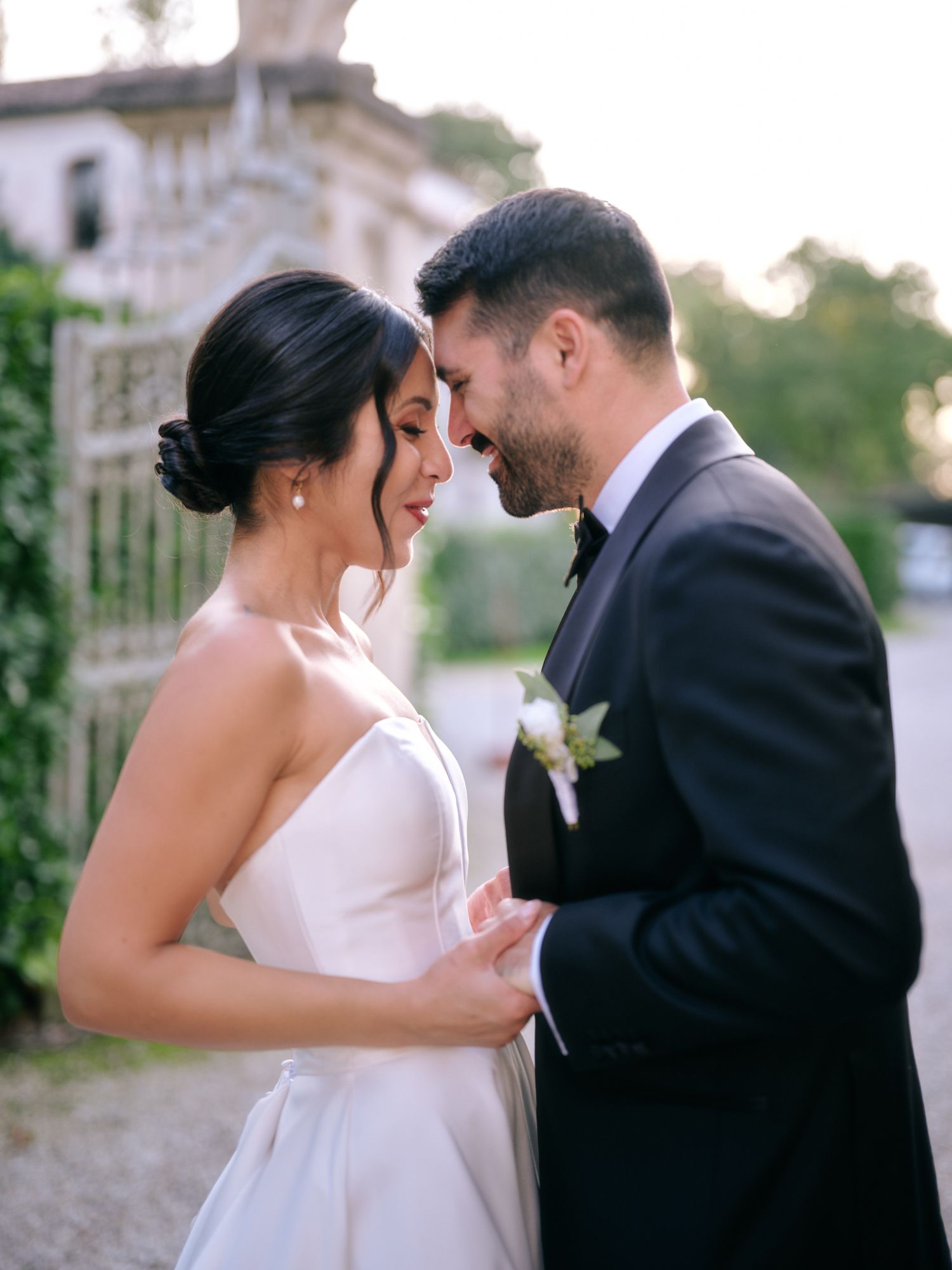 A romantic wedding couple shares intimate moments in a series of outdoor portraits at sunset.