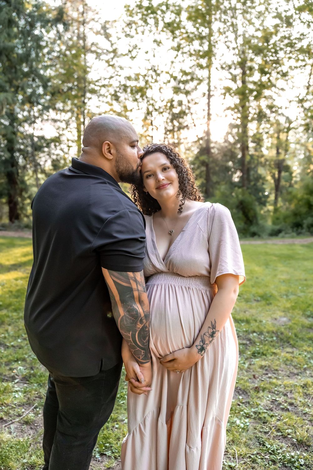 A couple shares intimate moments in a sunlit field during a romantic outdoor photoshoot.