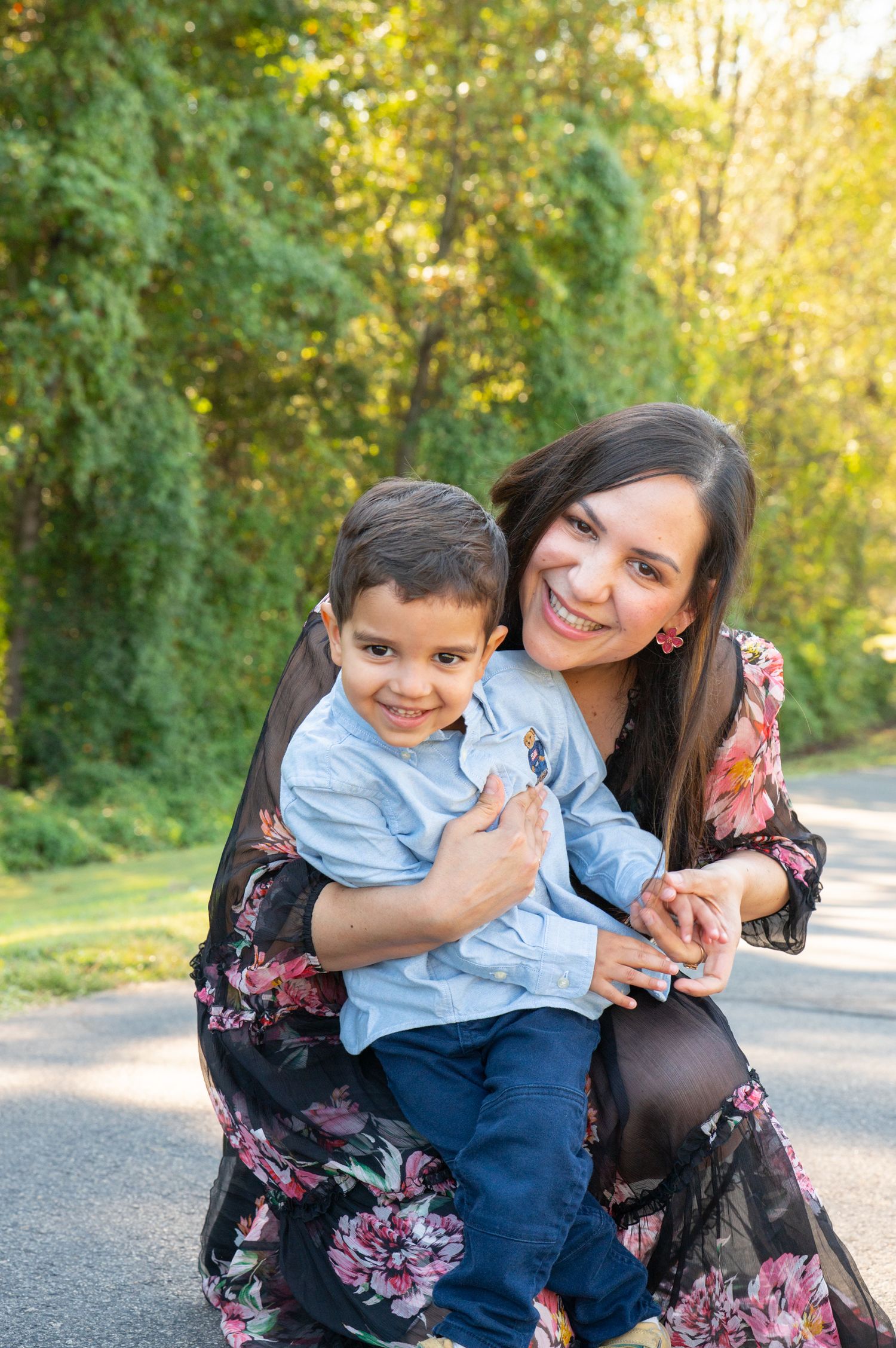 A heartwarming outdoor photo showing a tender moment between Mom and son on a sunlit path, during a family session in Northern Virginia