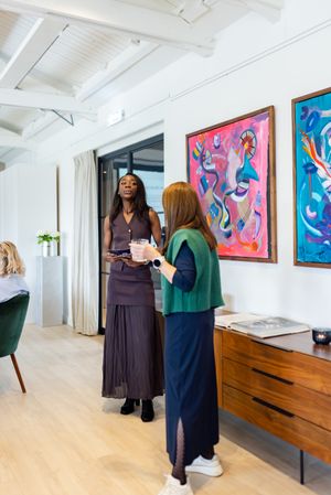 Office interior featuring vibrant wall art and people in conversation.