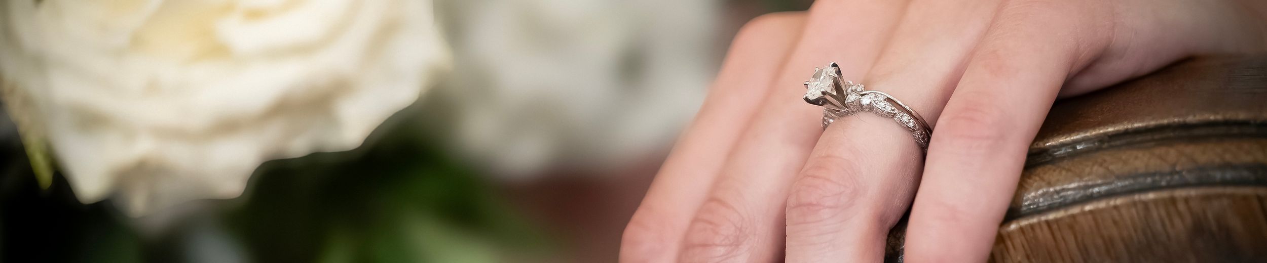 Alyssa's wedding and engagement ring in a tight shot as she places her hand on a church pew