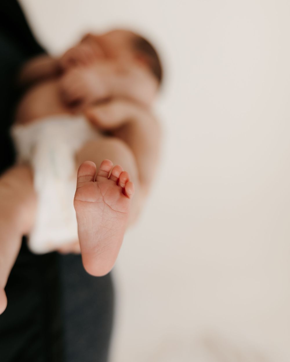 Close-up artistic shot of tiny baby foot against light background.