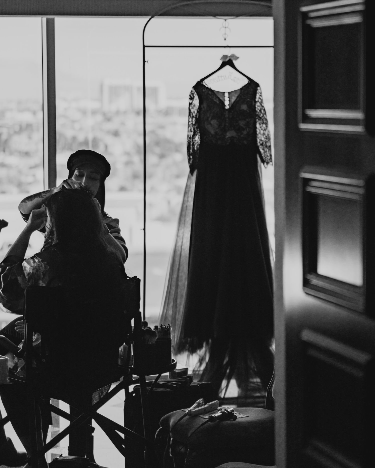 Black and white photo series showing silhouettes of elegant dresses hanging in a room with natural light coming through windows.