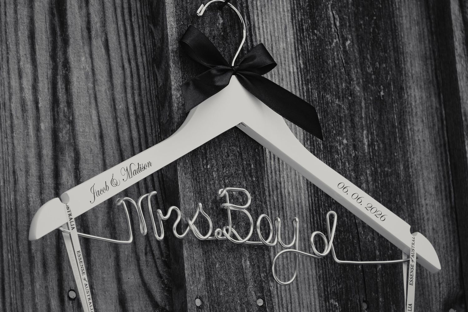 Custom white wedding hanger with wire Mrs.Boyd name and black bow, personalized bridal gift in black and white photo.