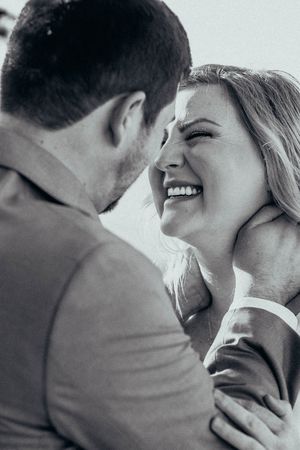 Black and white intimate romantic portrait of a couple laughing and embracing in a candid joyful moment.