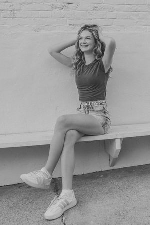 black and white photo senior girl hands on head laughing