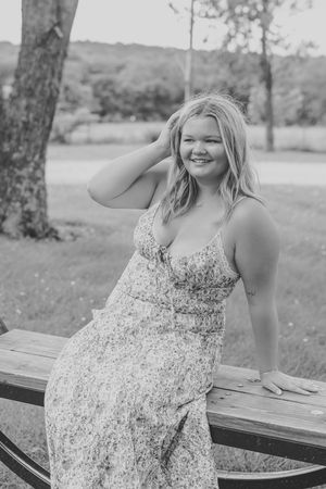 black and white photo senior girl floral dress on swing