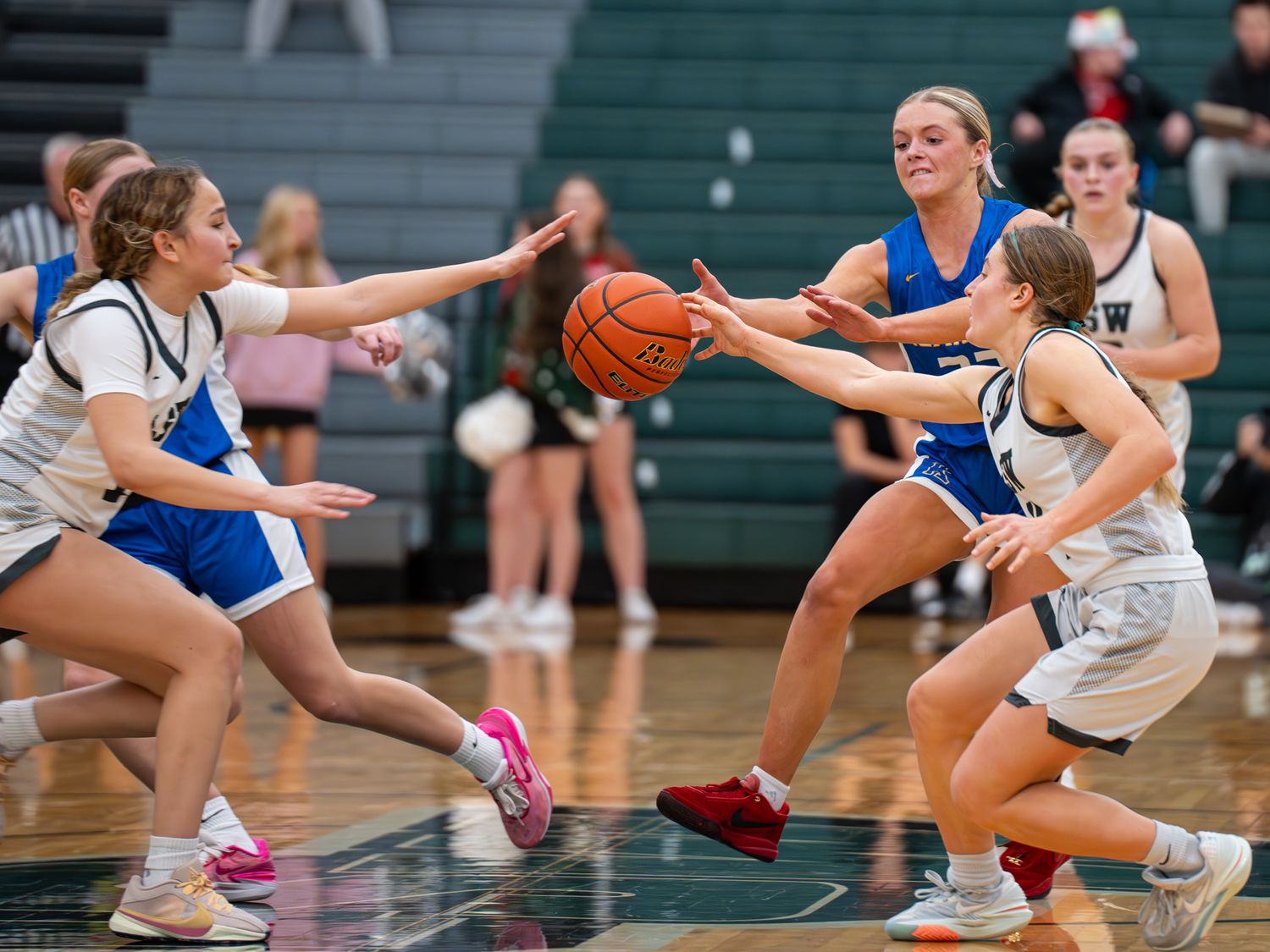 Intense basketball action as players from opposing teams battle for possession of the ball.