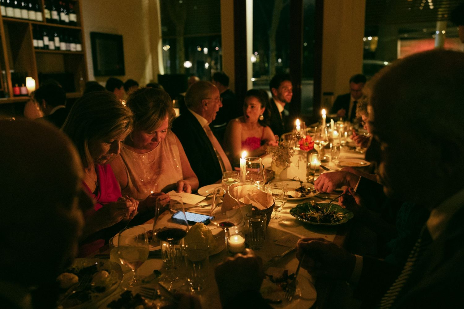 overhead photograph of a wedding dinner in Switzerland, couple leans in to kiss as they celebrate after their wedding ceremony