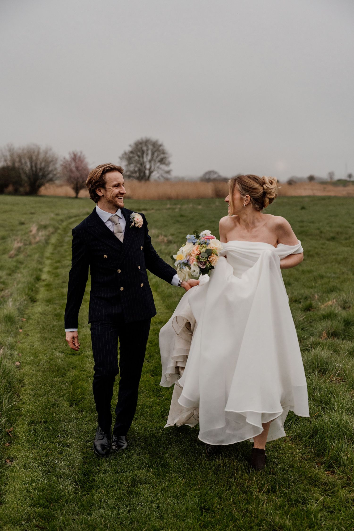 Bride and groom smiling and walking in the gardens at Quantock Lakes.