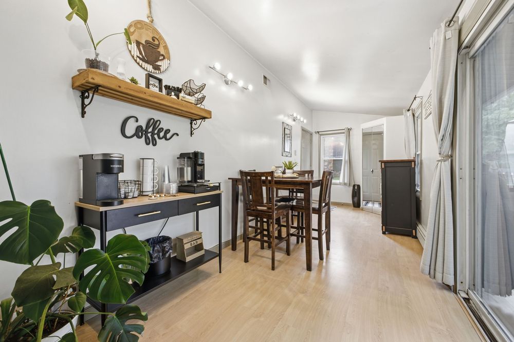Cozy dining nook with coffee station, wood floors, and sliding door in a modern home interior.