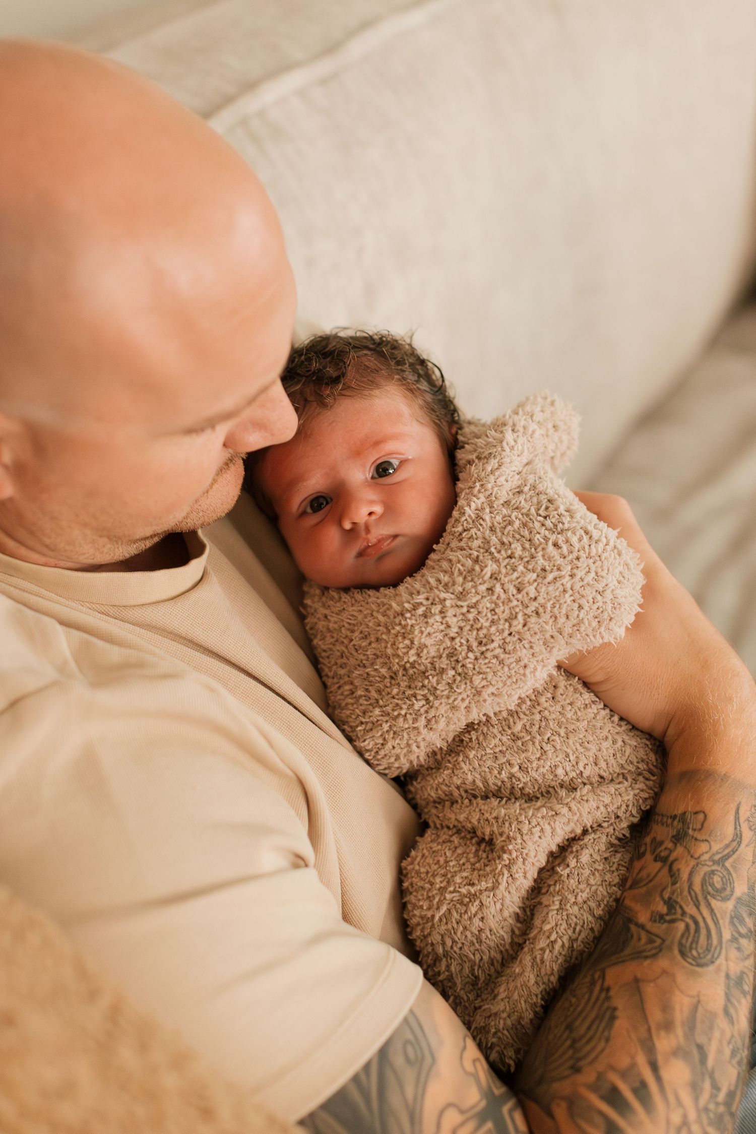 dad holding newborn baby wrapped in blanket