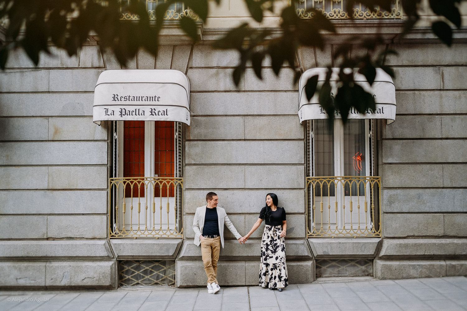 Couple holding hands outside Restaurant La Paella Real in Madrid.