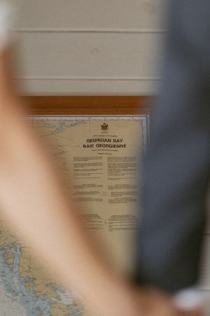 Framed Georgian Bay nautical chart map hanging on a wall, partially obscured by blurred figures in the foreground.