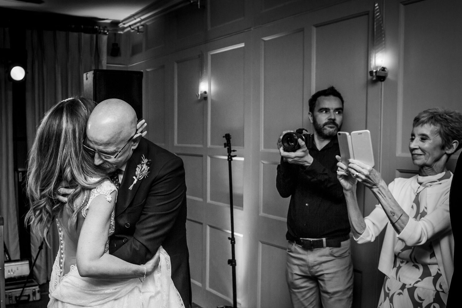 dad dancing with daughter while mom photographs on mobile phone