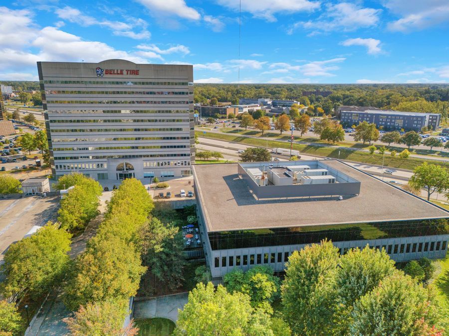 Aerial view of Belle Tire headquarters building surrounded by trees in a suburban office park setting.