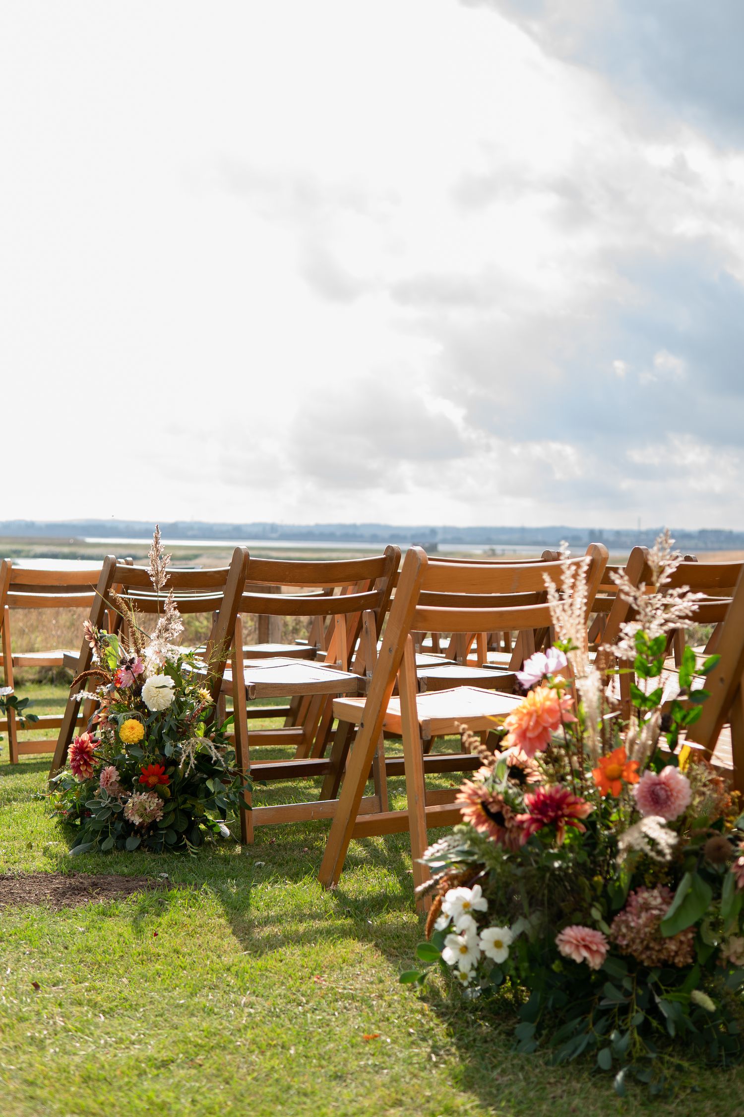 Stunning wild & natural meadow boxes lining rows of chairs at an outdoor wedding | Flowers created by BLOOM Fabulous | Flowers grown in Kent