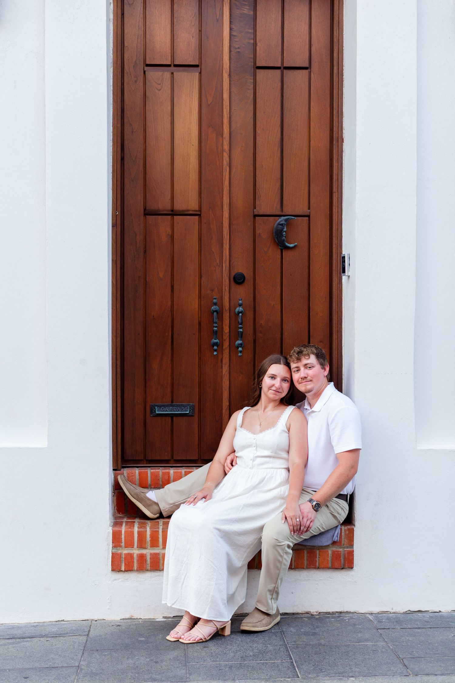 Couples portrait seated in a doorway. Engagement photo session in Old San Juan, Puerto Rico.