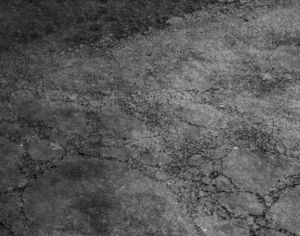 Textured gray surface showing dried and cracked salt patterns.