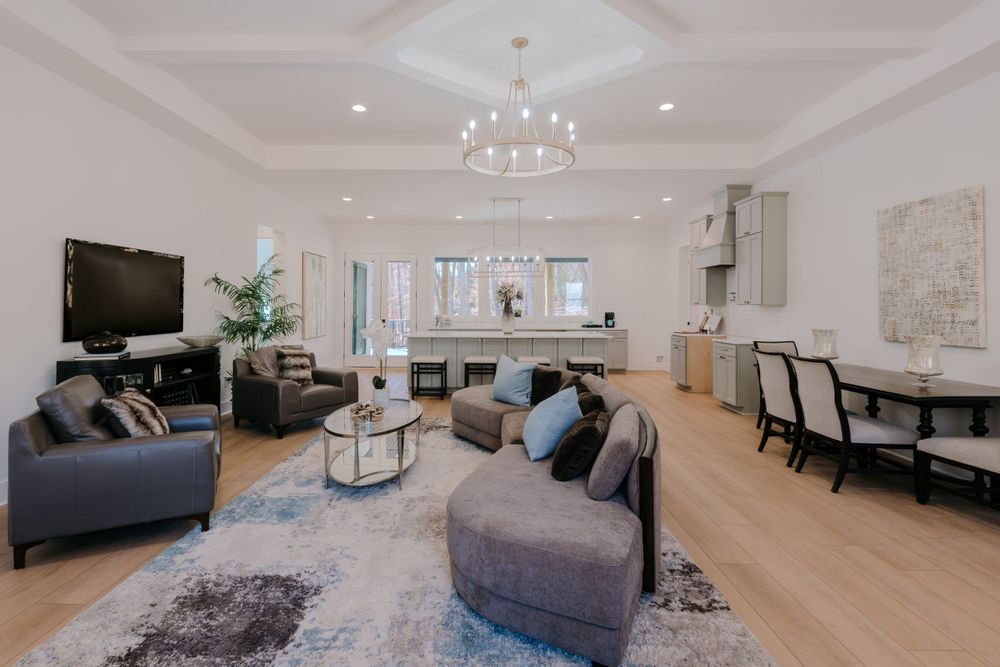 Contemporary open concept living room with coffered ceiling and light hardwood floors.