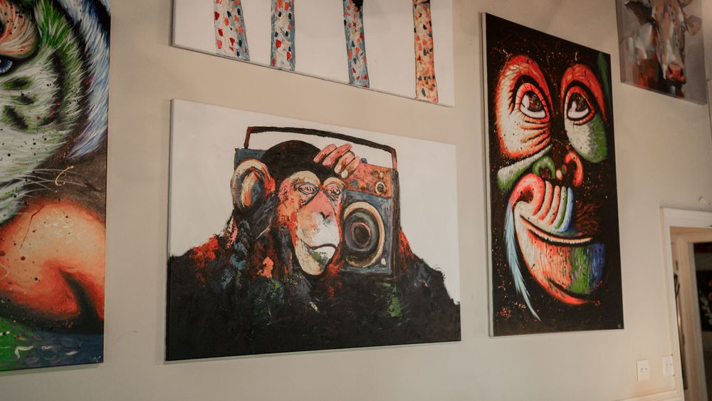 Colorful wall gallery featuring urban art prints with monkey and mask designs.