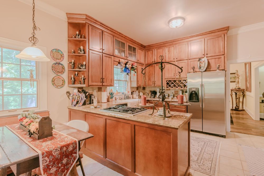 Warm kitchen with natural wood cabinets, stainless appliances, and granite countertops.