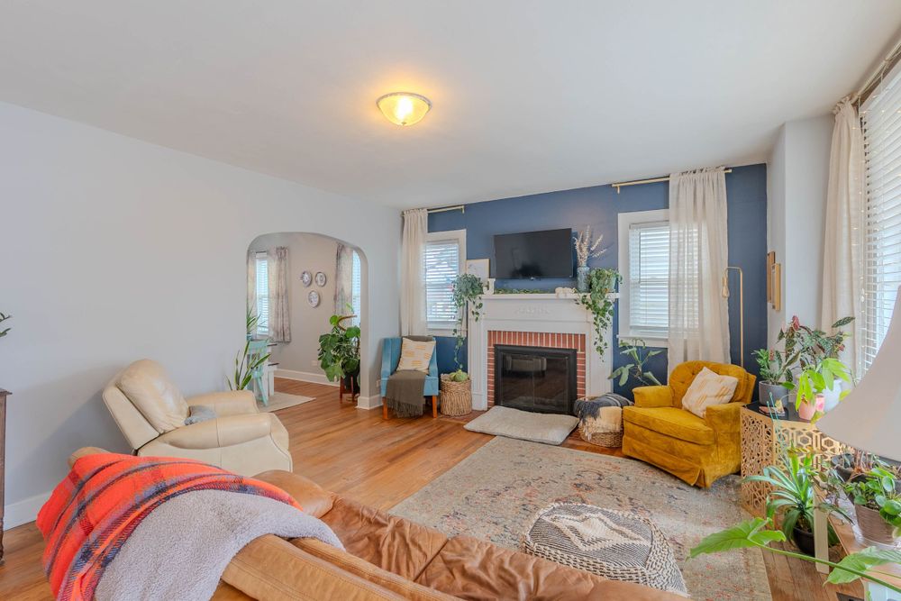 Cozy living room with fireplace, yellow accent chair, and warm lighting.
