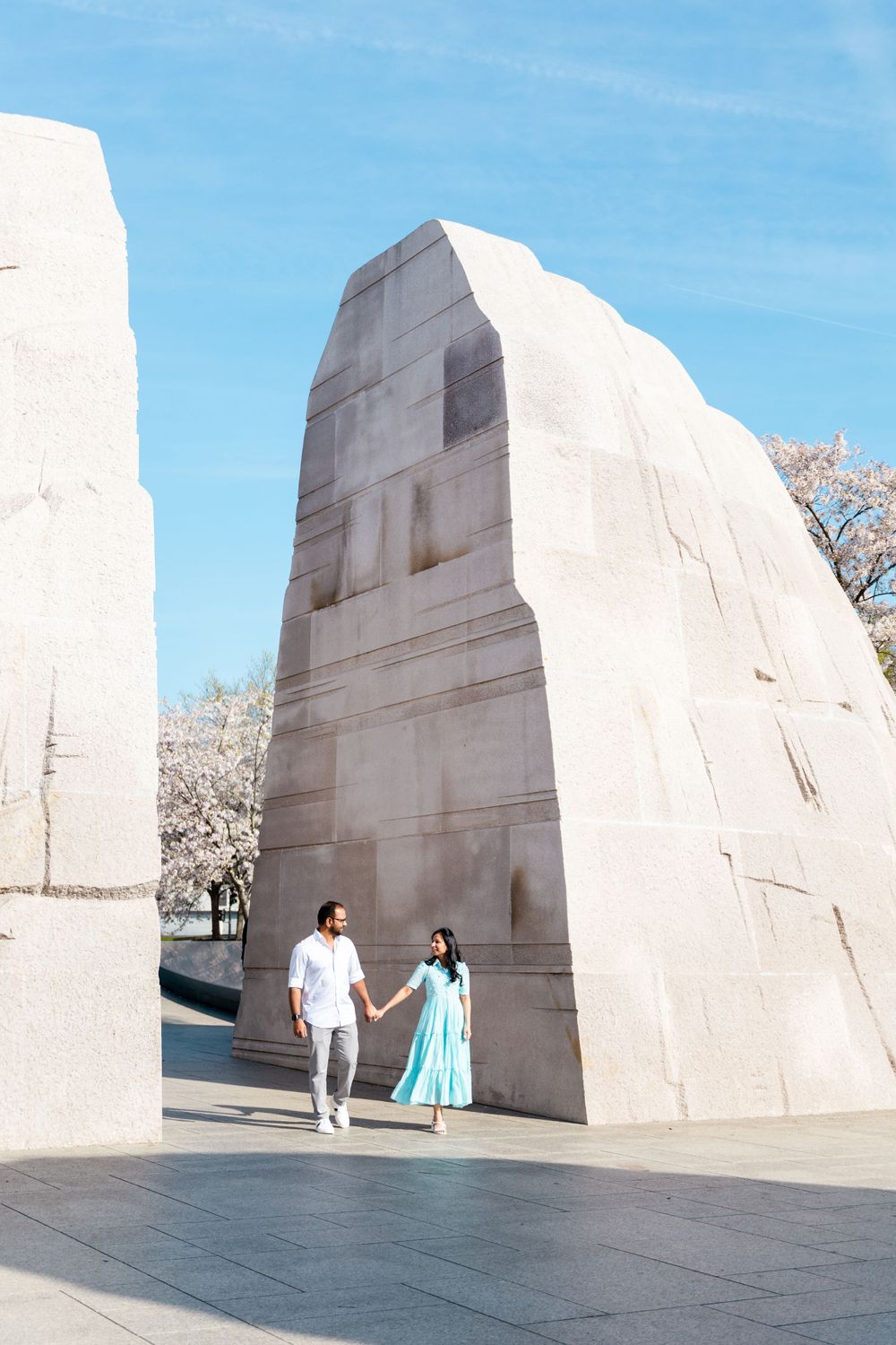 A couple poses at the MLK Memorial in Washington DC with its iconic white stone walls.